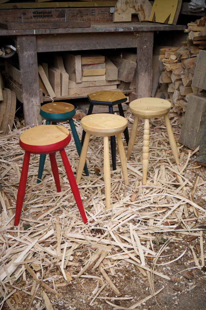 Wooden stools on workshop floor with shavings.