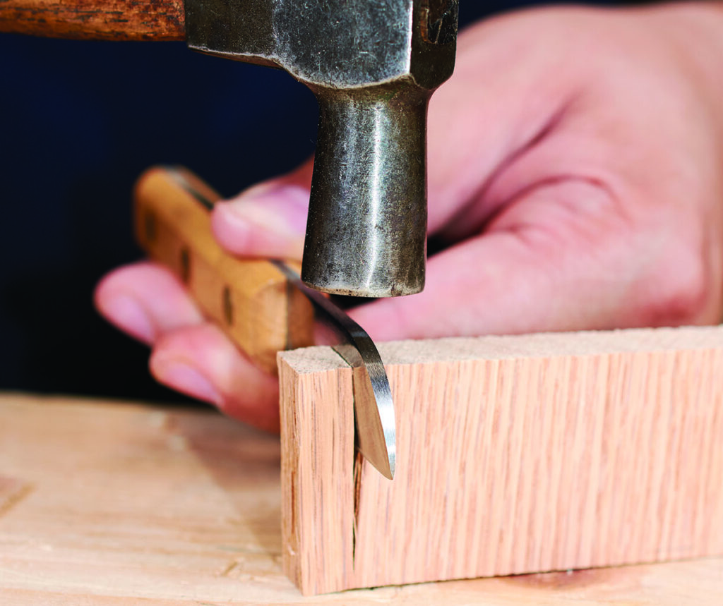 Chisel and hammer carving wood block