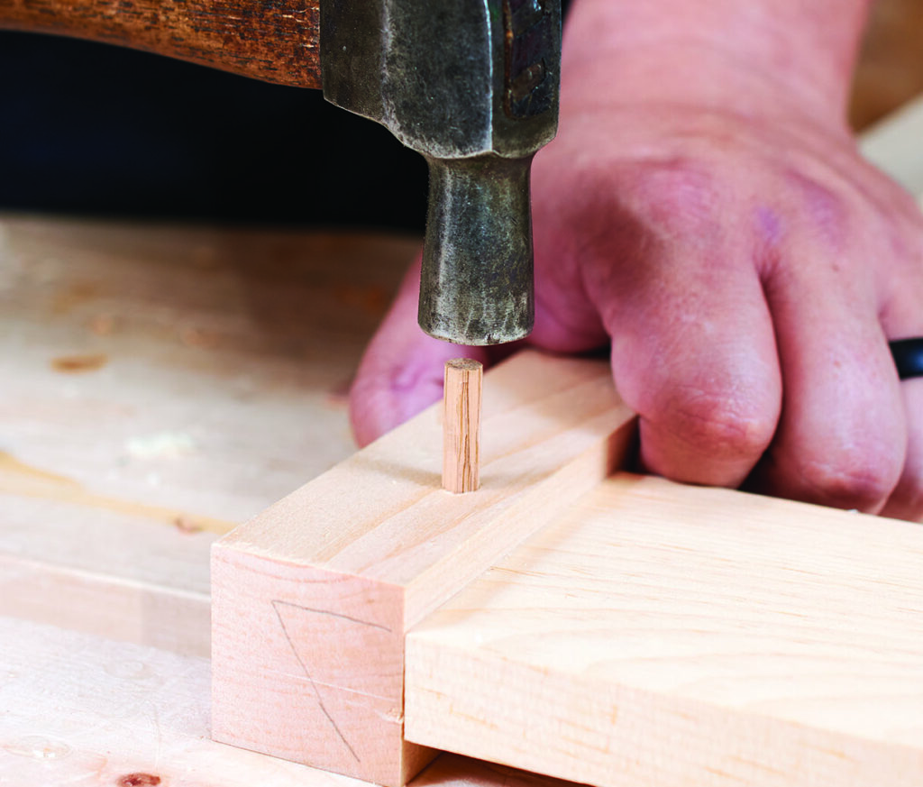 Hammering wooden dowel into joint