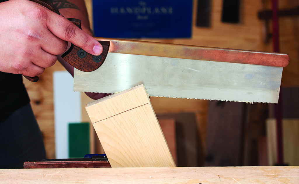 Person sawing wood in workshop