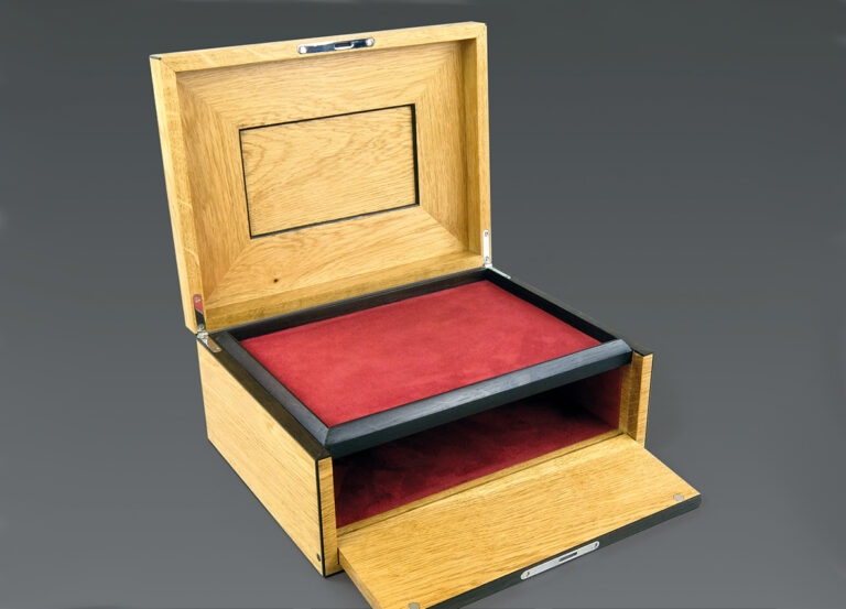 Wooden box with red velvet interior, open lid.