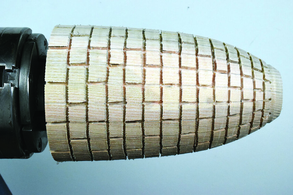 Sanded wooden piece on a lathe.