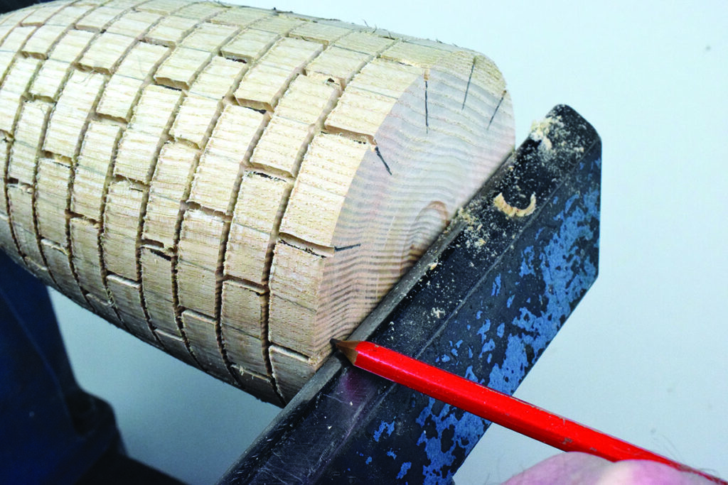Woodturning pattern with red pencil marking guidelines.
