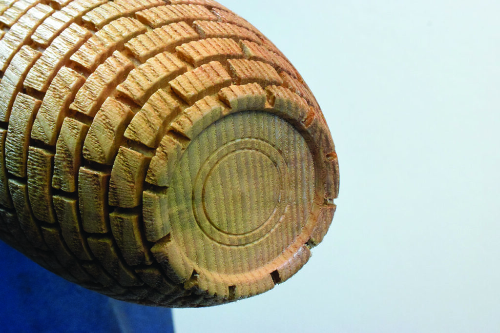 Close-up of carved wooden cylinder end.