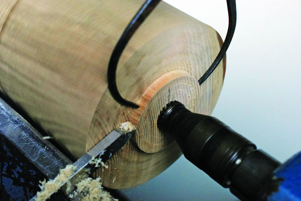 Woodturning process on a lathe producing shavings.