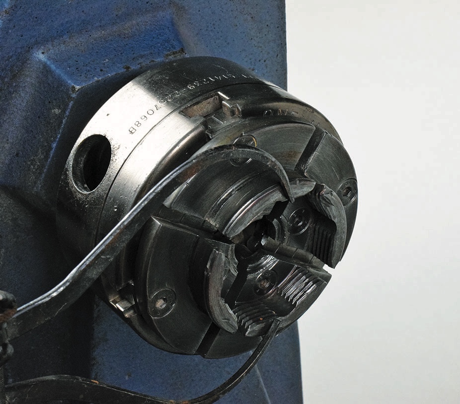 Metal lathe chuck on industrial machine.