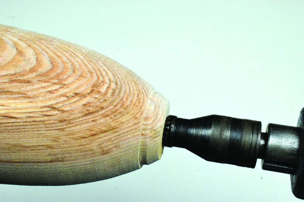 Wooden object being sanded by power tool