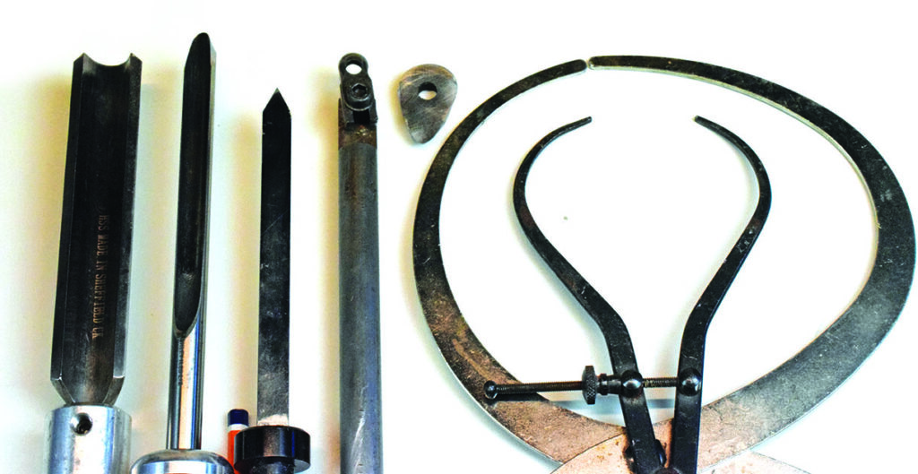 Woodturning tools and caliper on white background.