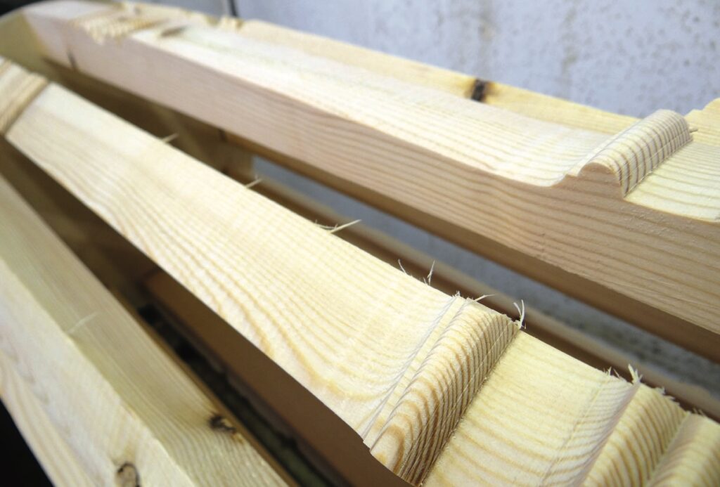 Close-up of wooden board edges with grooves.