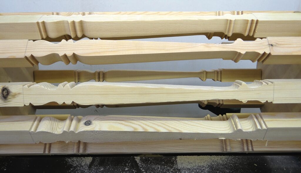 Wooden stair balusters stacked vertically.