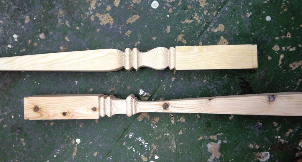 Two carved wooden pieces on worn surface.