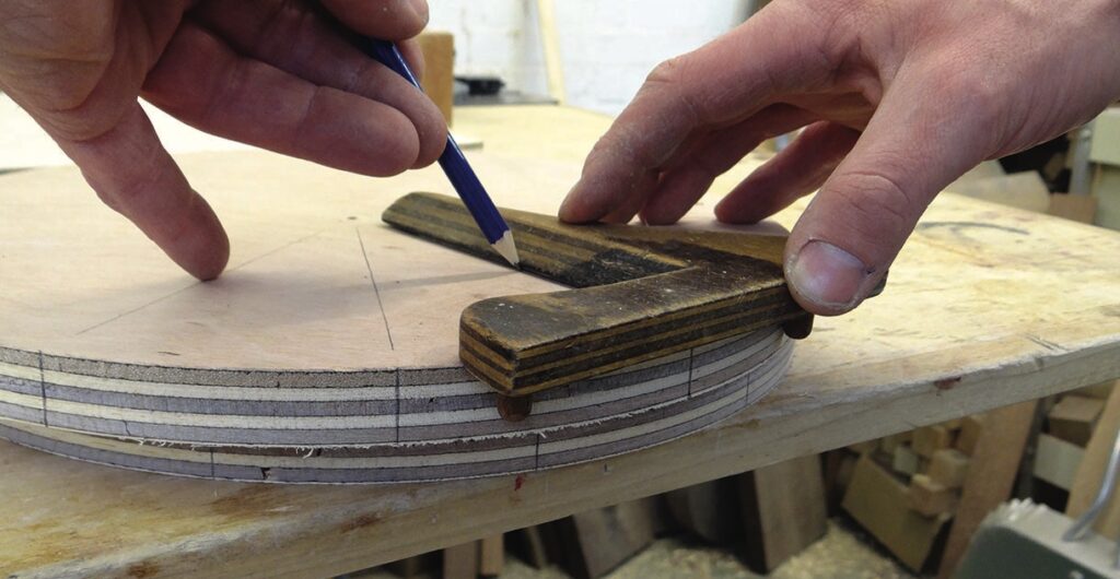 Close-up of woodworking with pencil and template