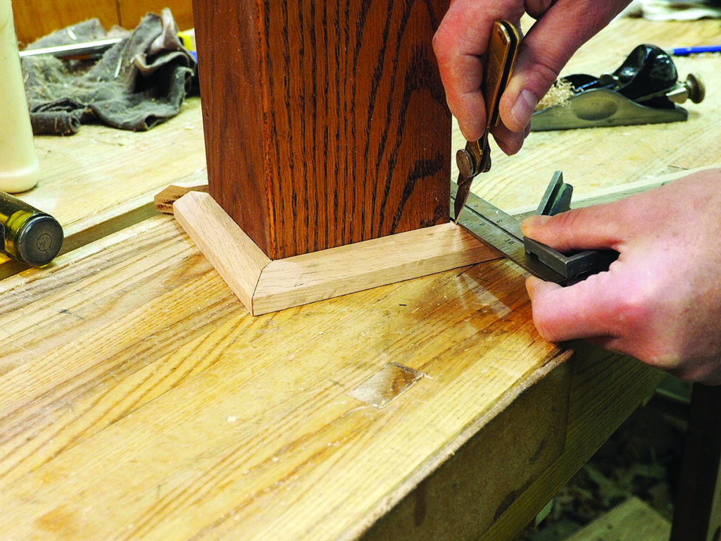 Measuring wood angles with precision tools on workbench.