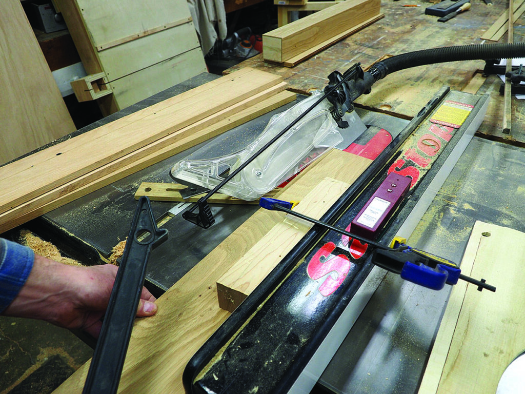 Woodworking with table saw and clamps in workshop.
