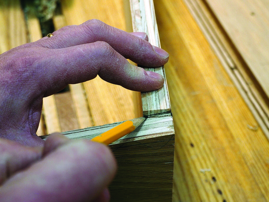 Person marking wood for precise cutting