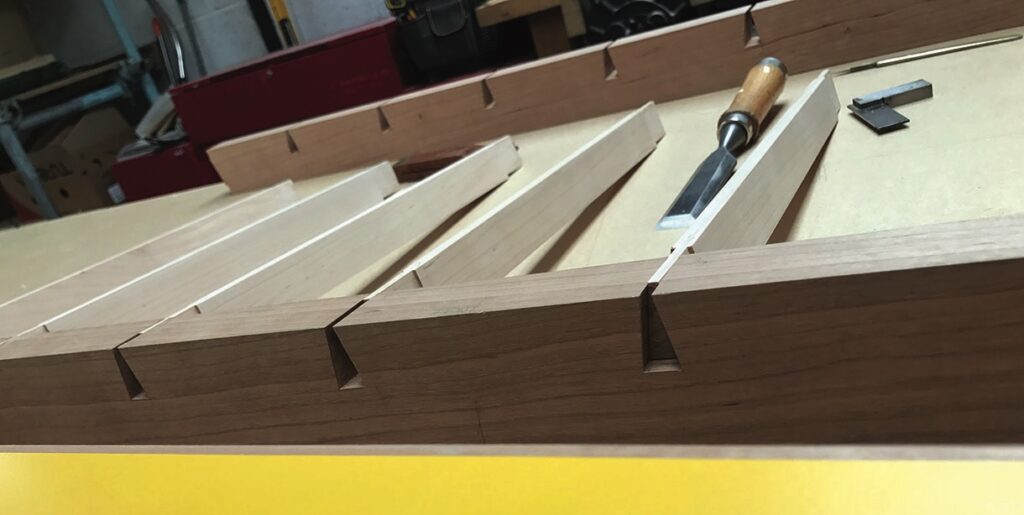 Woodworking dovetail joints with chisel and tools.