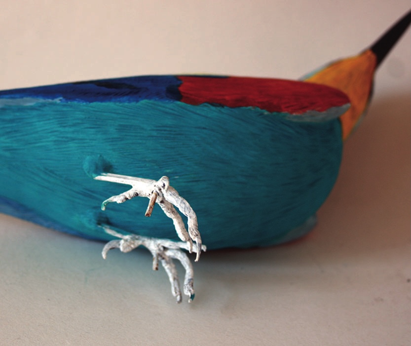 Colourful bird sculpture with metal legs