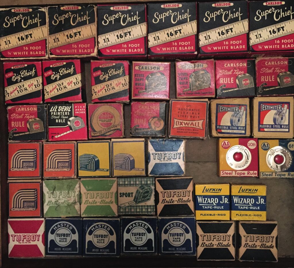 Collection of vintage tape measure boxes on display.