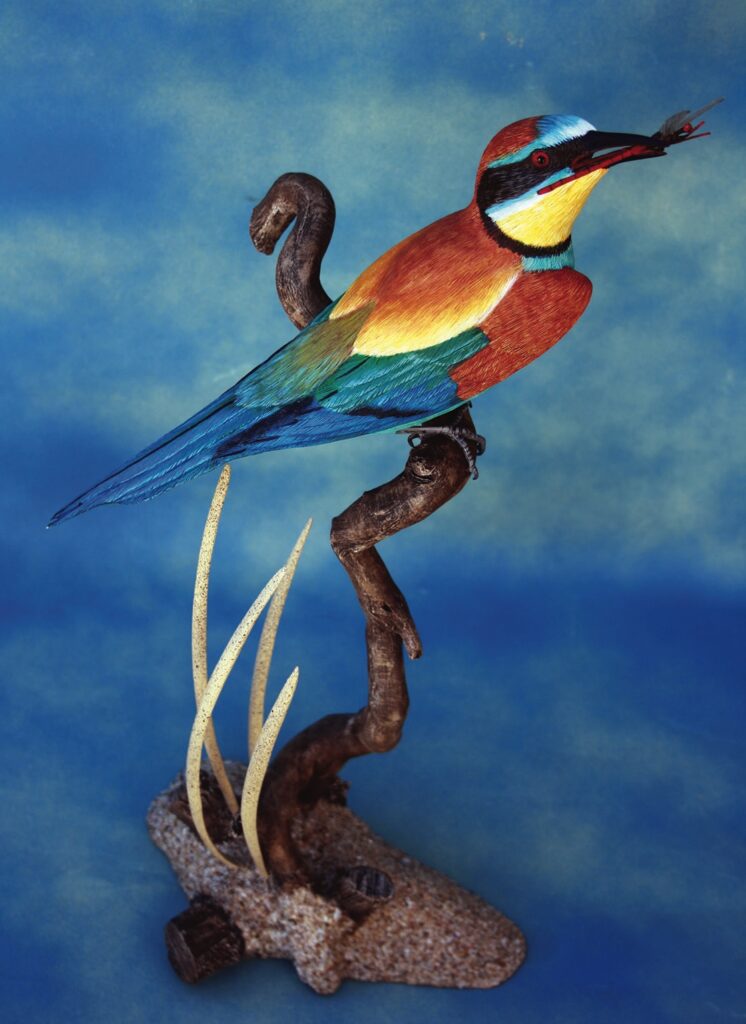 Colourful bird model perched on branch sculpture.
