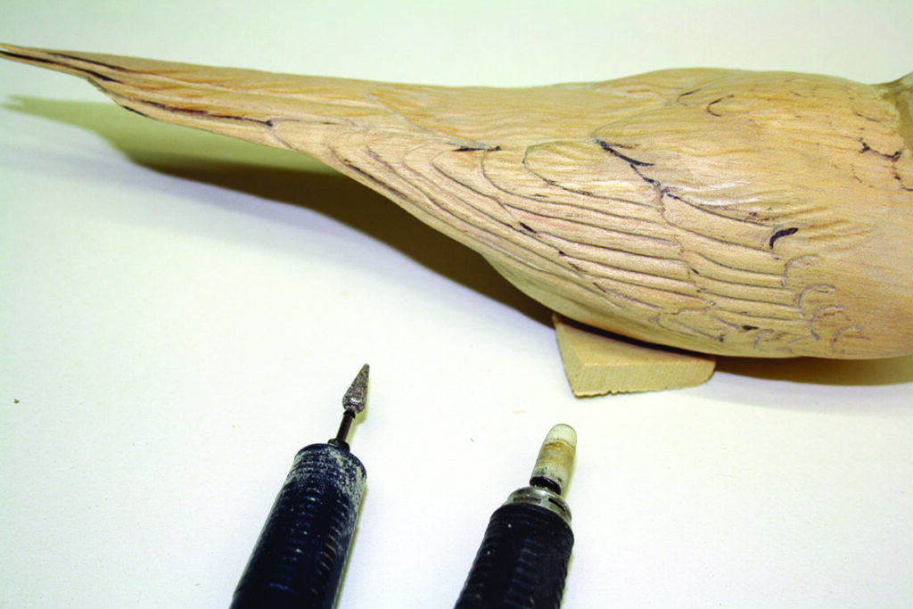 Wood carving tools next to bird sculpture