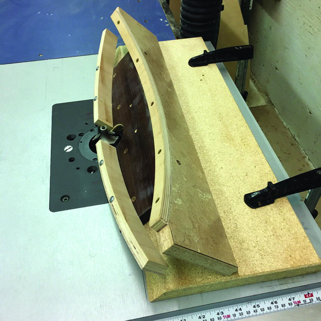 Woodworking router jig on workbench.