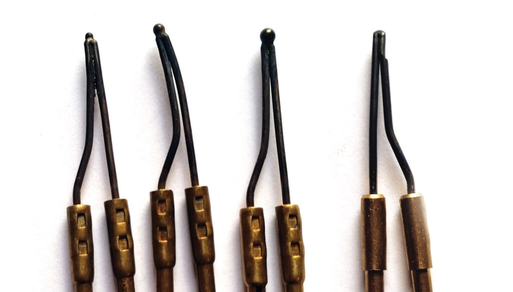 Seven dental scaler instruments on white background.