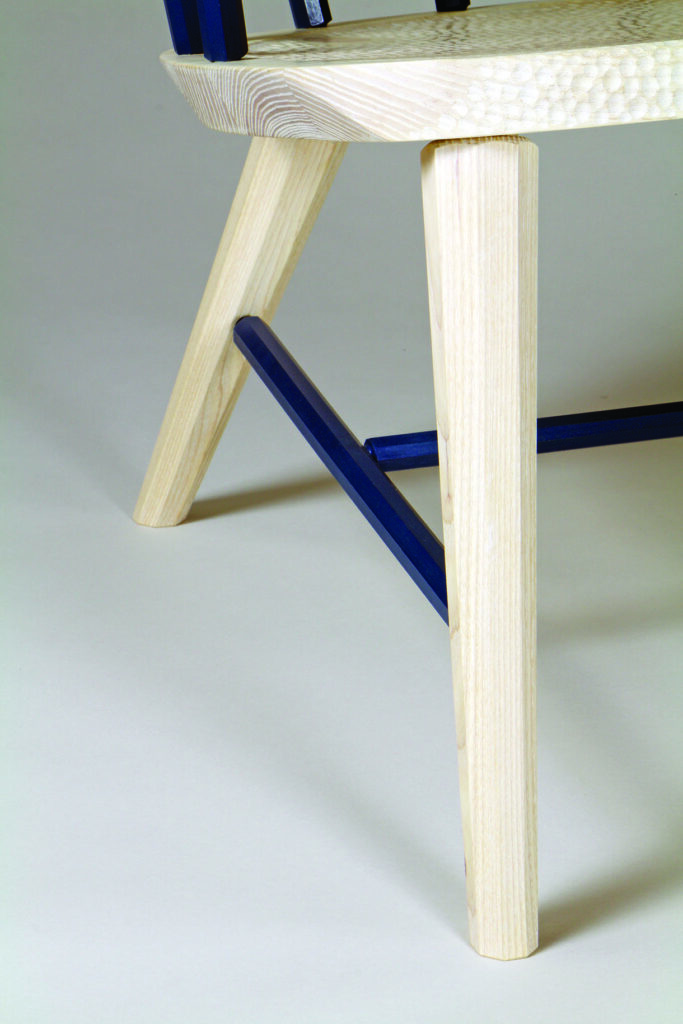 Modern chair with wooden legs, blue support detail.