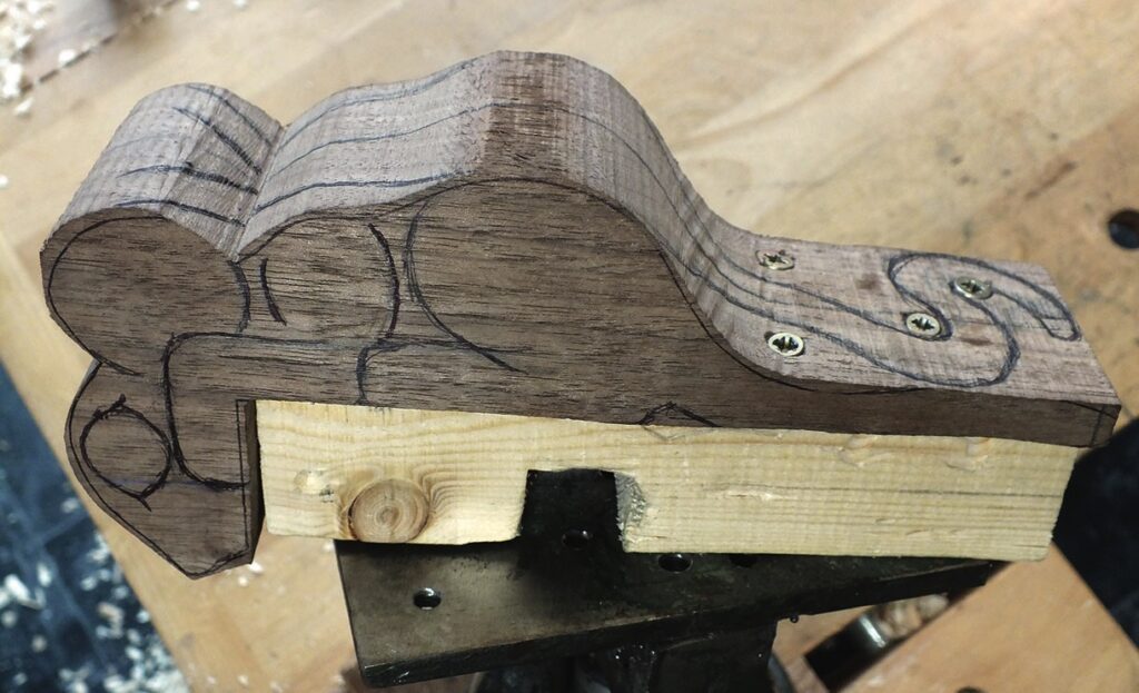 Wood piece with carved design in workshop.