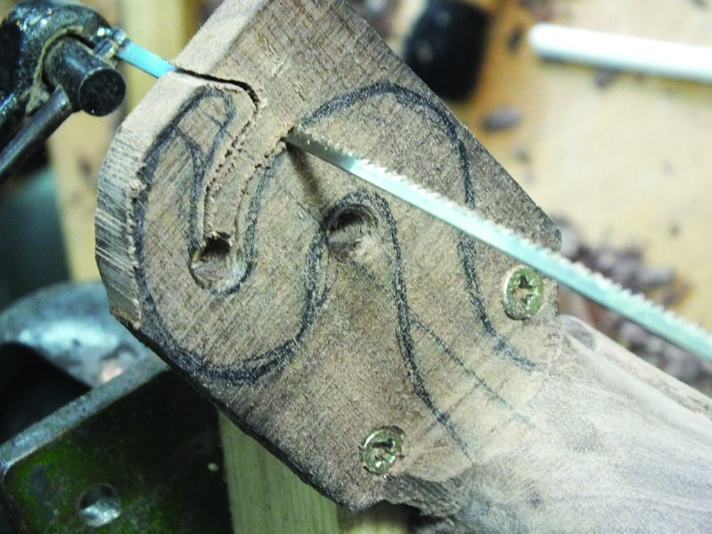 Scroll saw cutting intricate wood pattern