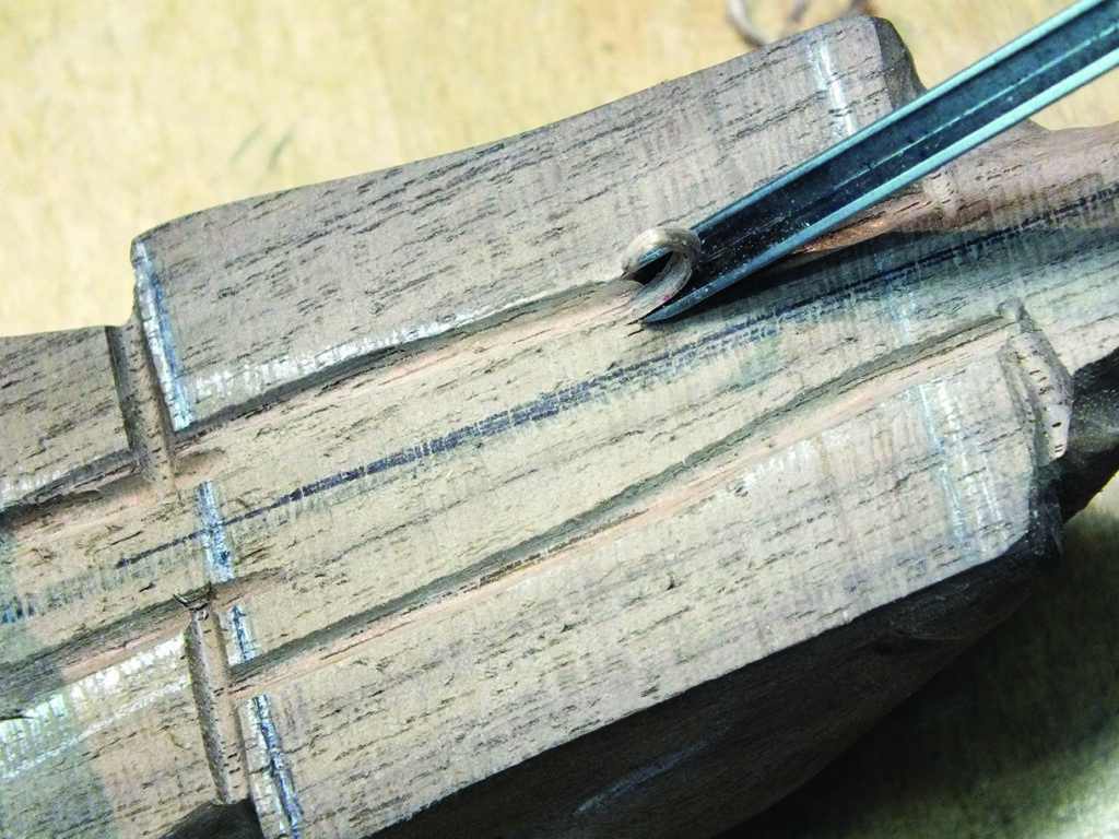 Wood carving with gouge tool in progress.