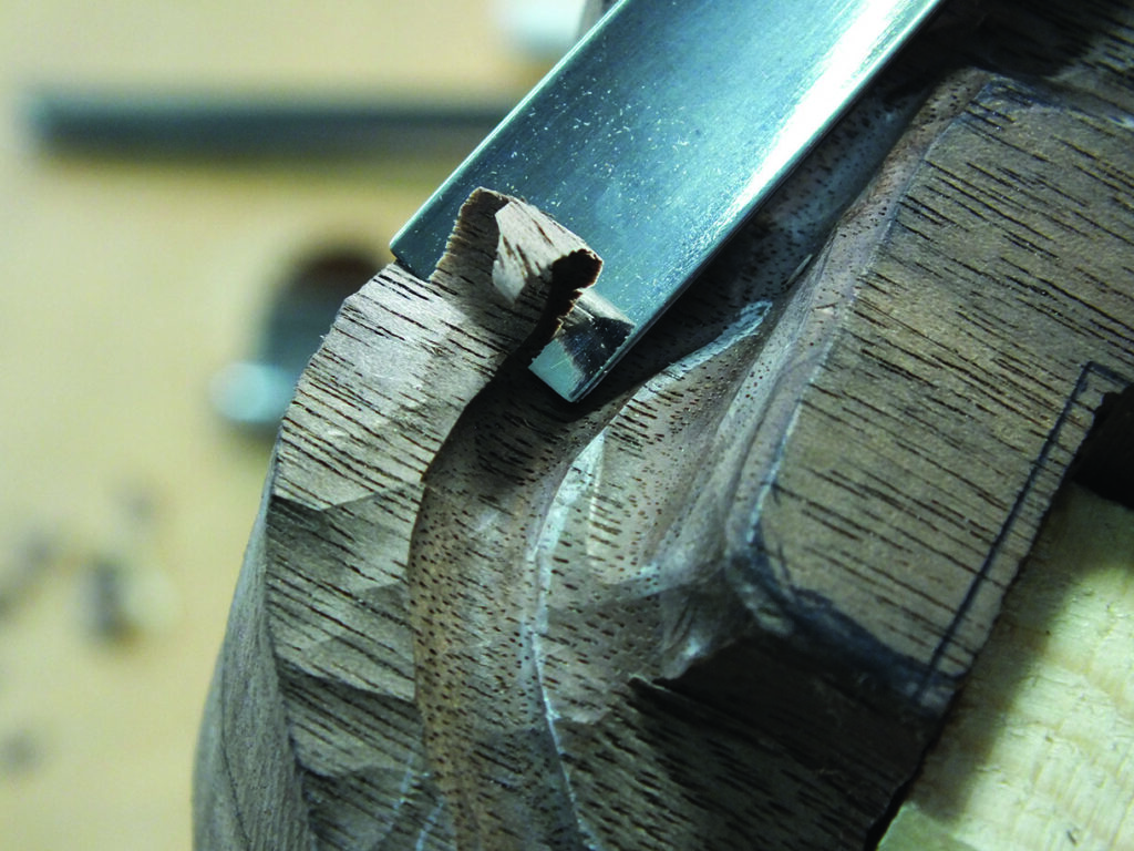 Chisel carving intricate details in wood surface