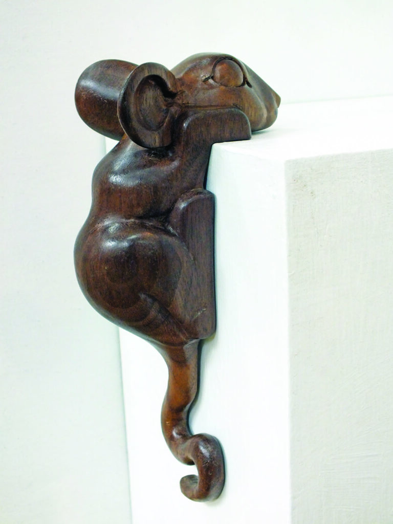 Wooden monkey sculpture on white corner