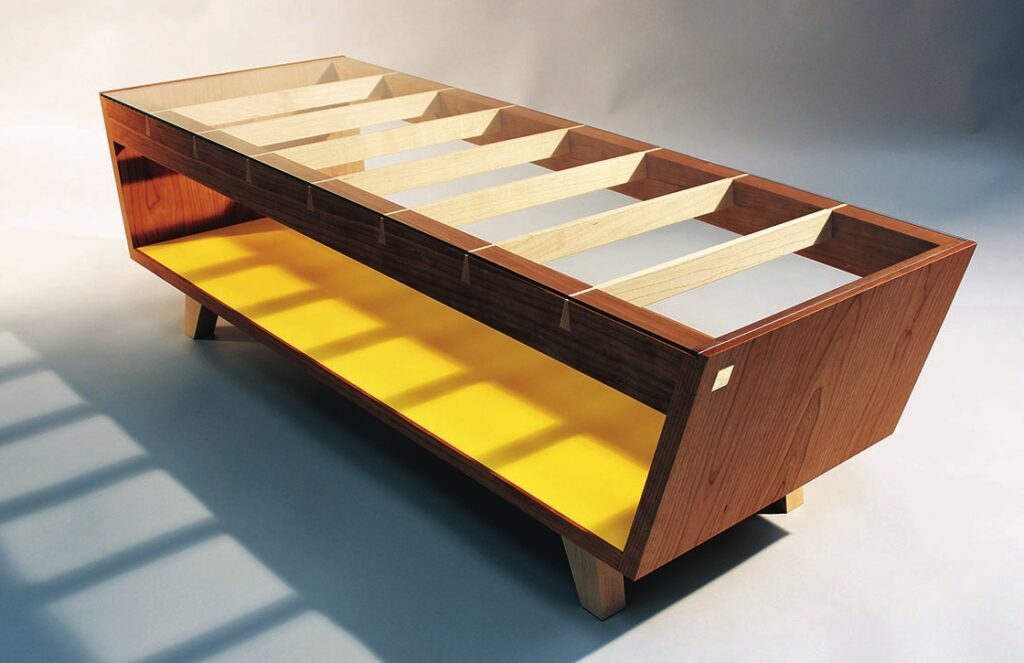 Modern wooden coffee table with yellow shelf.