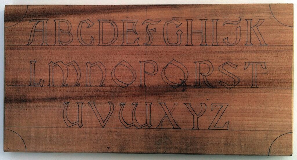 Wooden block with engraved alphabet letters.