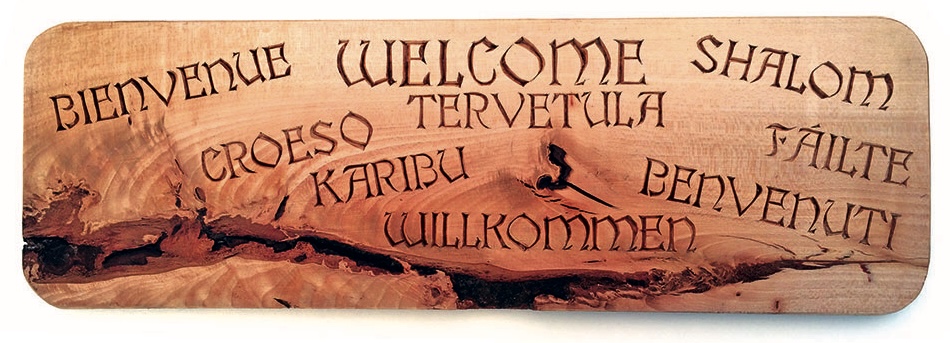 Wooden welcome sign in multiple languages