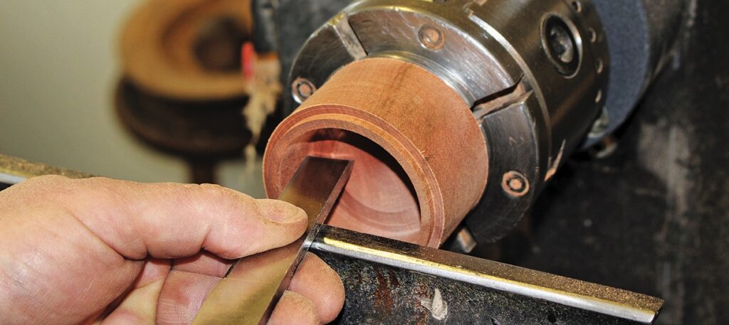 Woodturning: hand shaping wood on a lathe.