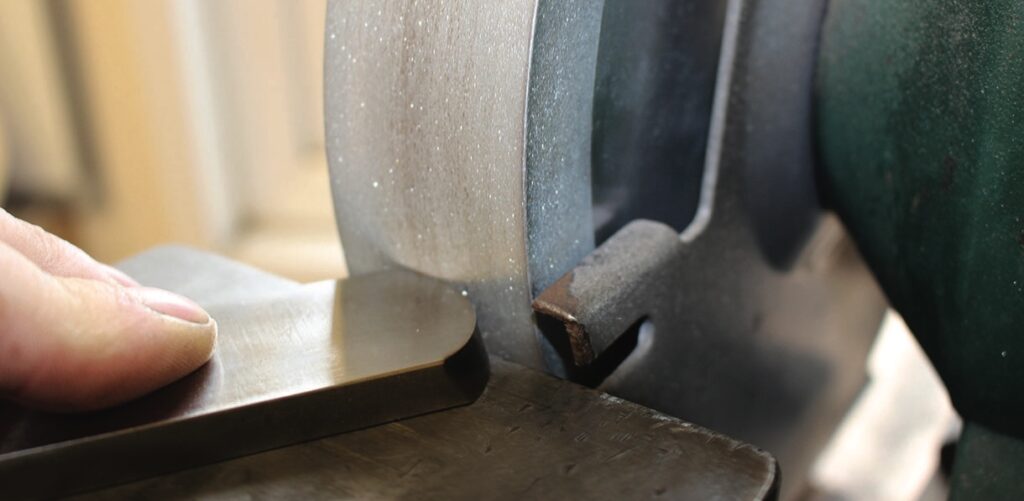 Sharpening tool on bench grinder close-up.
