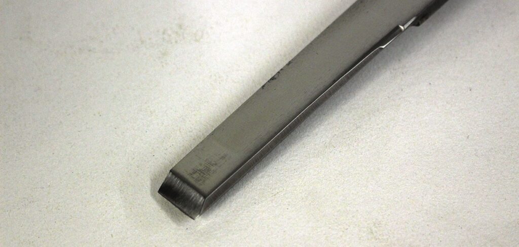 Close-up of a metal chisel on table