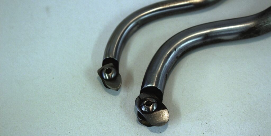 Close-up of metal tools on white surface.