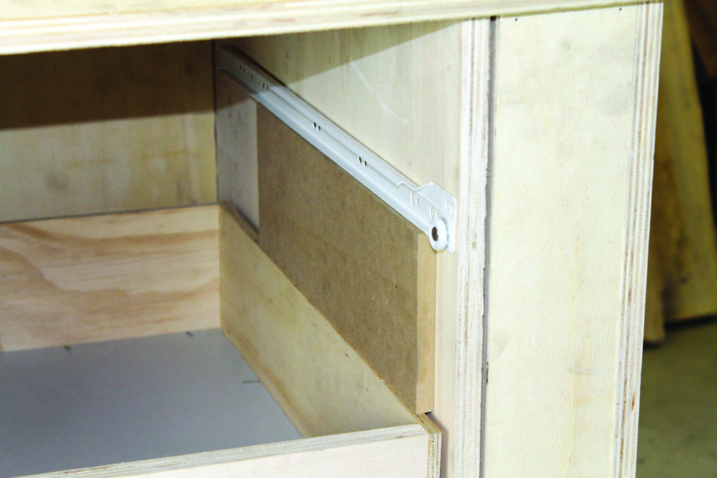 Wooden drawer with metal slide mechanism.