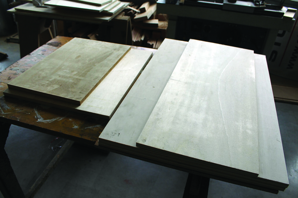 Plywood sheets stacked on workshop table