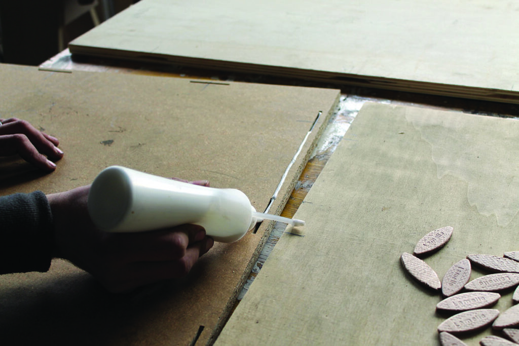Applying wood glue between wooden panels