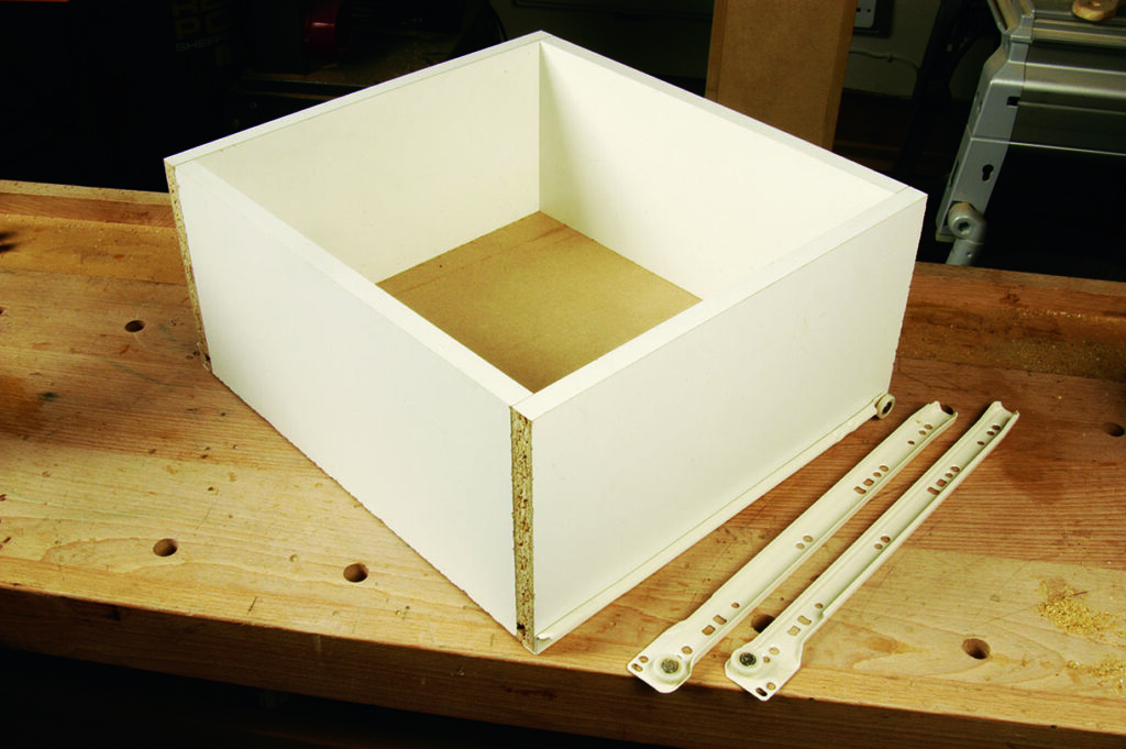 Assembling a wooden drawer on workbench.