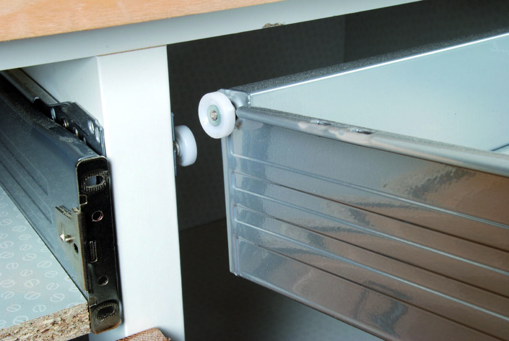 Metal drawer with roller mechanism installed under desk.