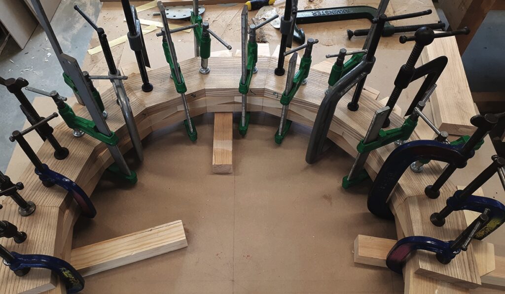 Wood pieces clamped in semicircle for construction