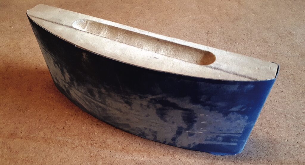 Sanding block with a wooden handle on surface.