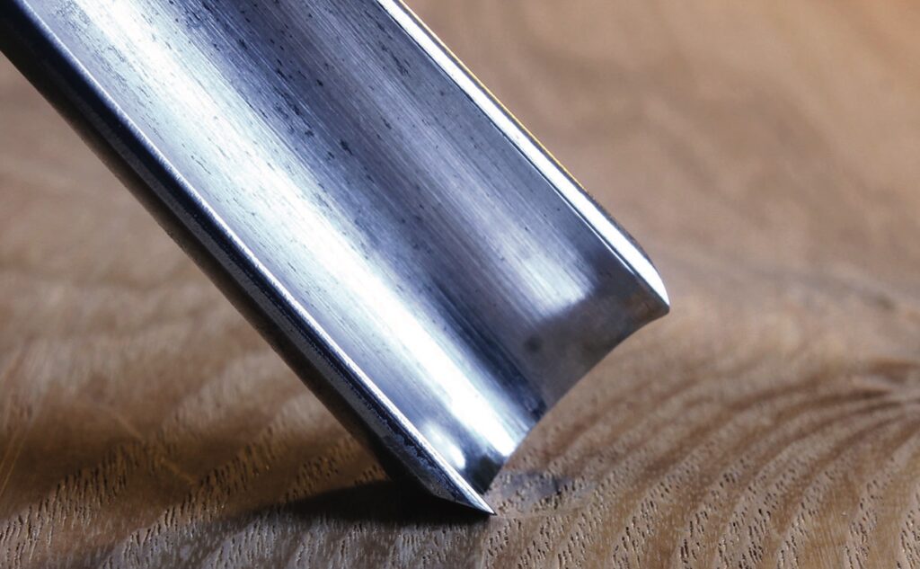 Close-up of polished metal tool on wood