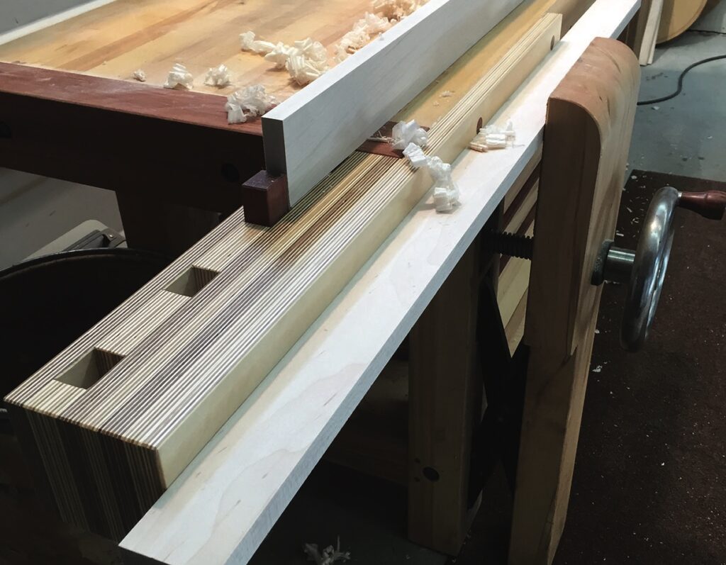 Woodworking vice holding wood on workbench