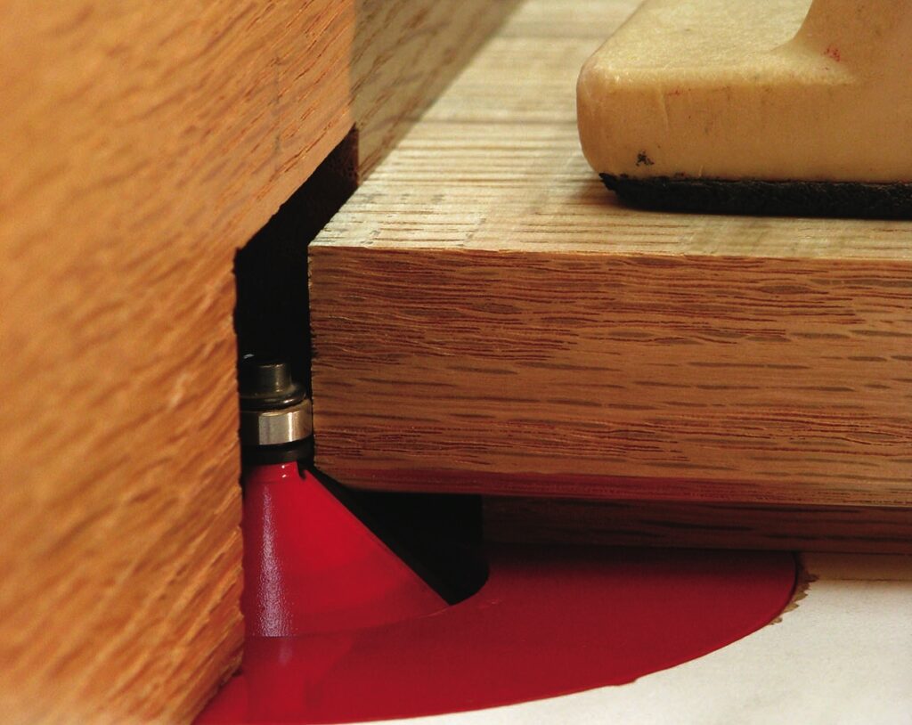 Router cutting groove in wooden board.