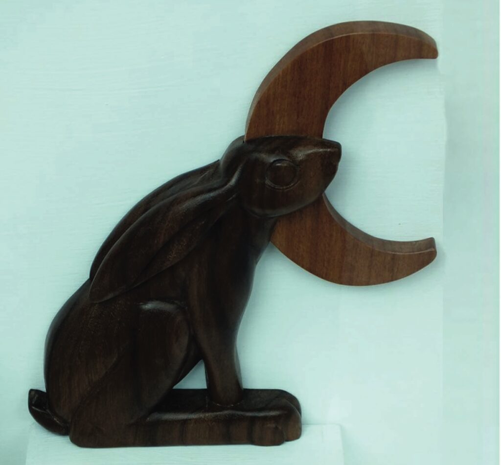 Wooden rabbit sculpture with crescent moon.